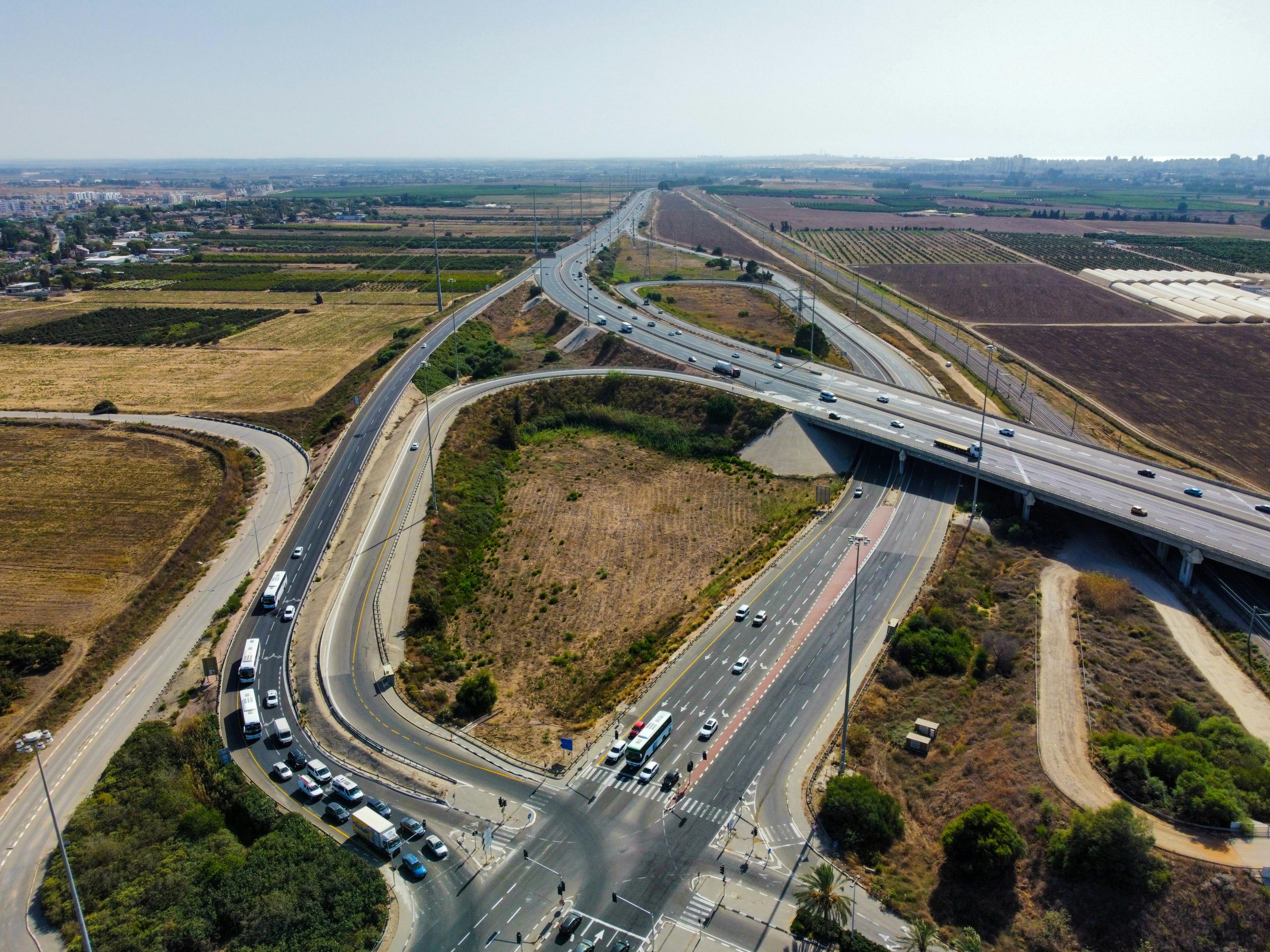Aerial view capturing a busy highway intersection surrounded by agricultural fields and open landscape.